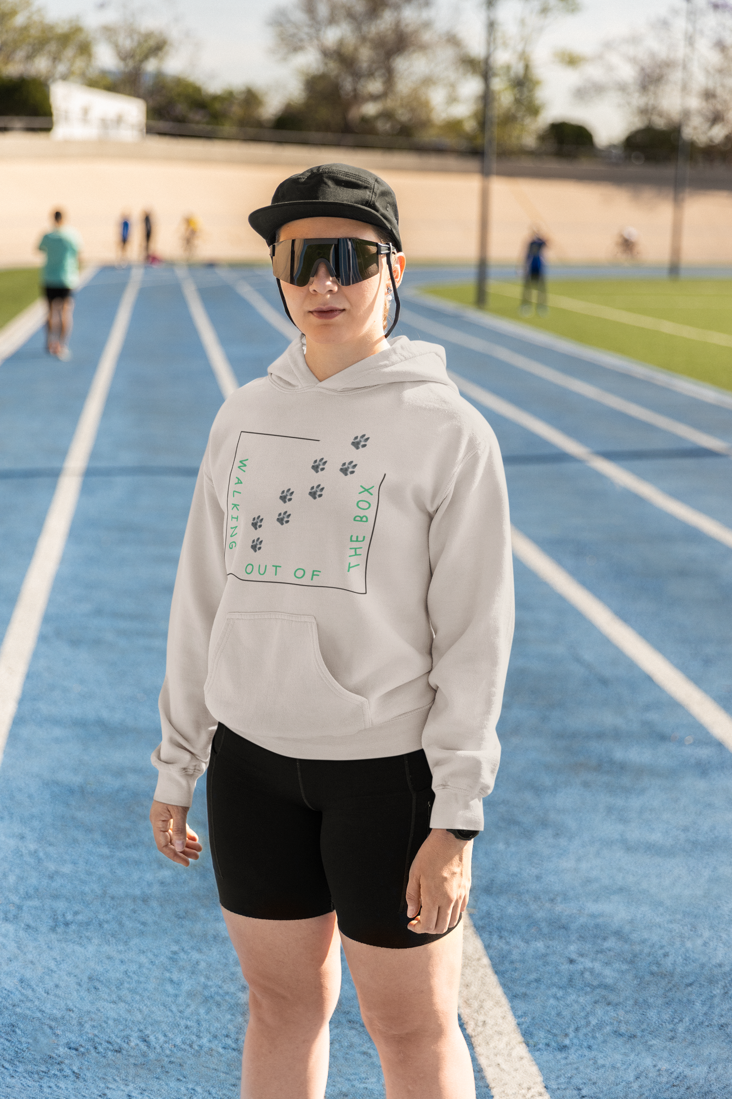 Bequemer Hundeliebhaber Hoodie für Damen und Herren in Weiß mit Pfotenprint und grünem Schriftzug getragen beim Outdoor-Training