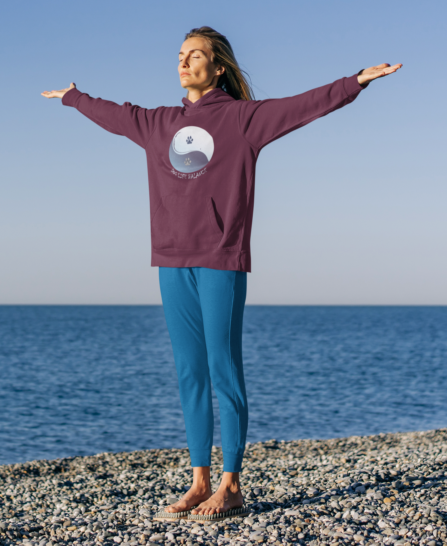 Milkis Way Bio Baumwolle Hoodie Hundeliebhaber in Bordeauxrot getragen am Meer auf Kiesstrand