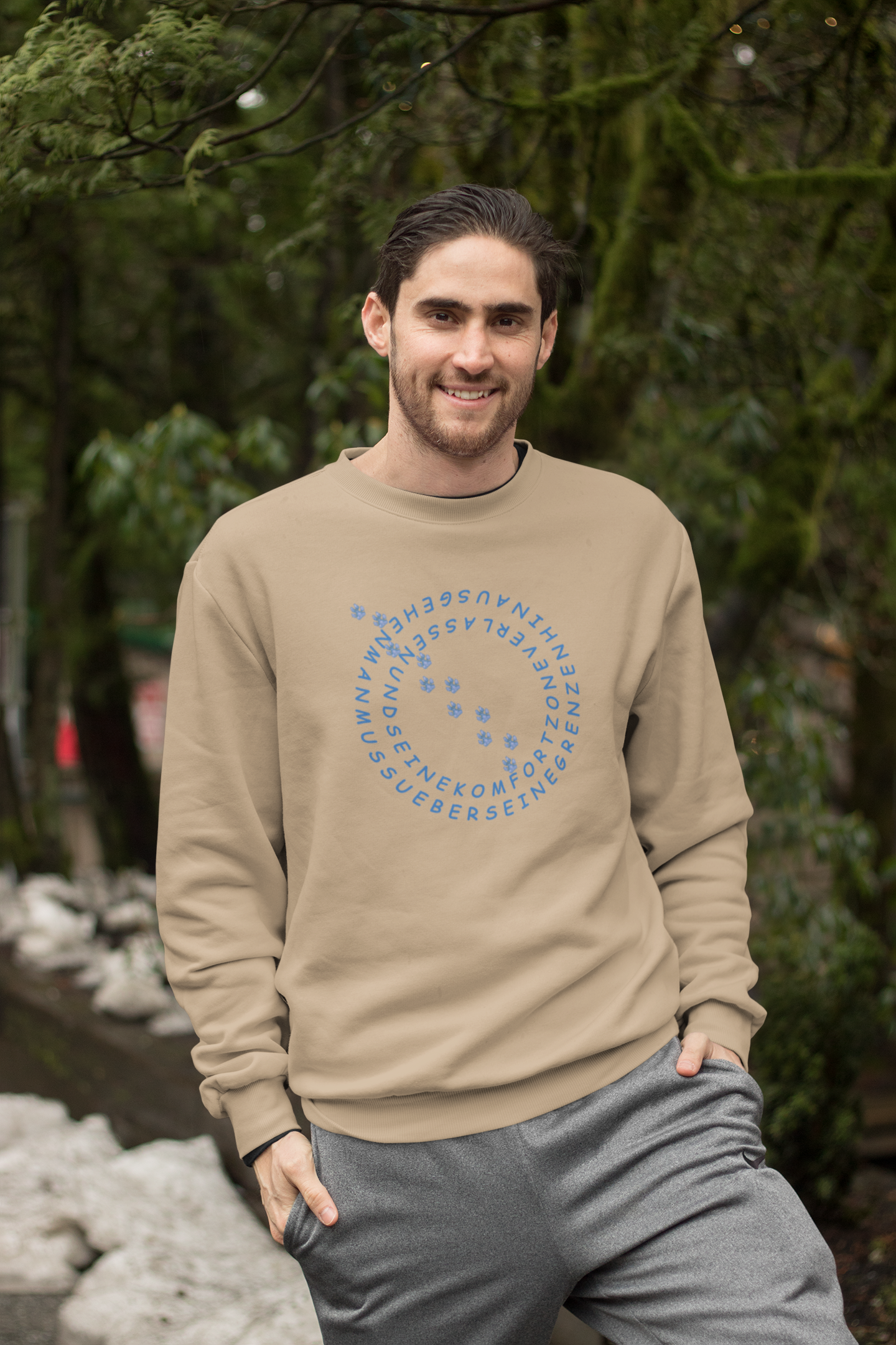 Beiger Milkis Way Bio Baumwolle Sweatshirt Hundeliebhaber mit blauem Schriftzug getragen von einem lächelnden Mann im Freien
