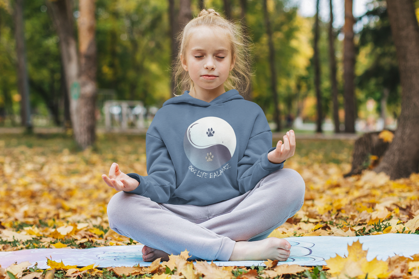 Bio Hoodie für Kinder mit Hundepfote von Milki´s Way in Blau mit Yin-Yang Motiv, getragen von Kind im Park