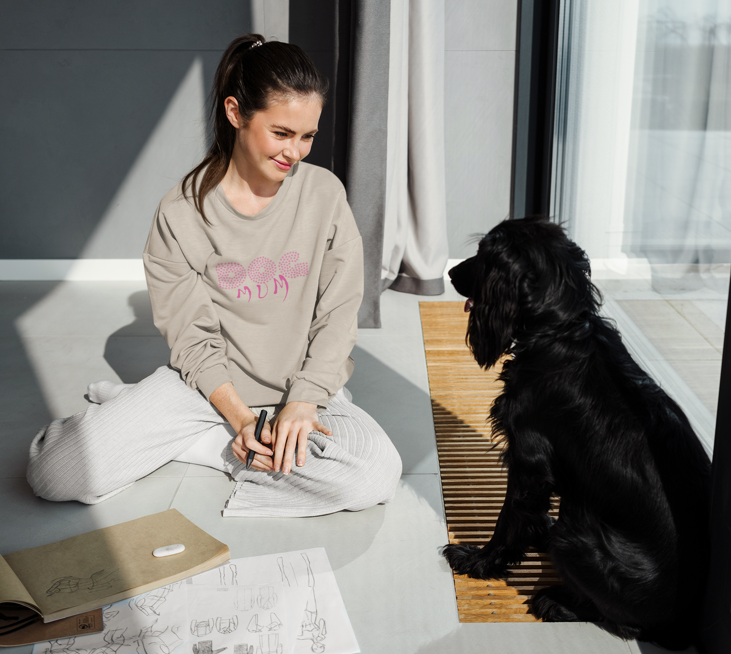 Milkis Way Dog Mum Sweatshirt Bio-Baumwolle in Beige getragen von Frau neben schwarzem Hund zu Hause