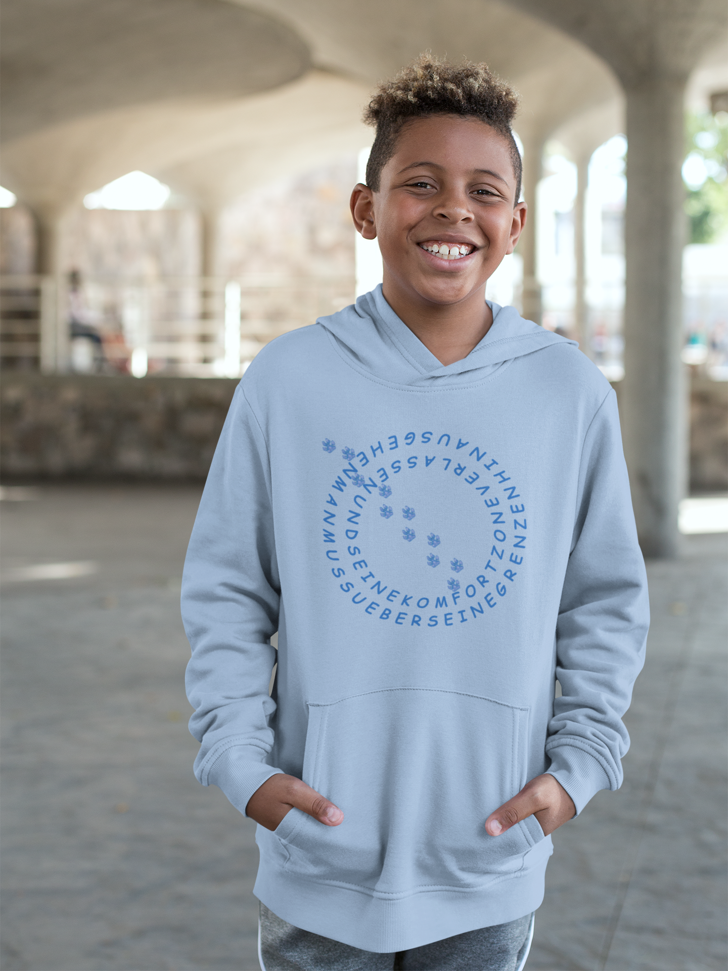 Nachhaltiger Hoodie für Kinder mit Hundemotiv von Milkis Way in Hellblau getragen von lächelndem Jungen