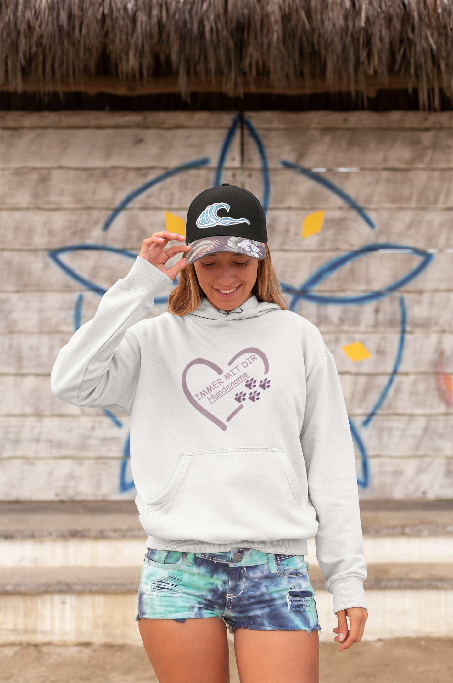 Weißer personalisierter Hoodie mit Hundepfote und Herzmotiv von Milki´s Way, getragen von Frau mit Cap