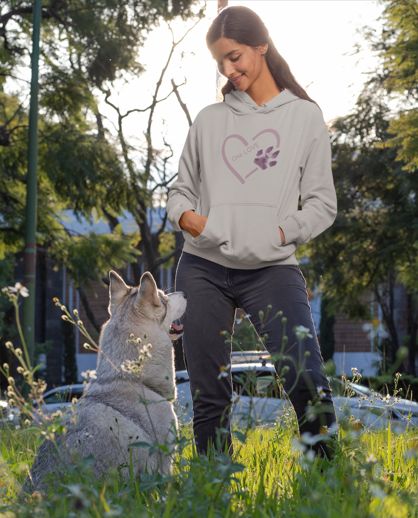 Unisex Hoodie Hundepfote Bio-Baumwolle von Milkis Way getragen von Frau im Park mit grauem Hund