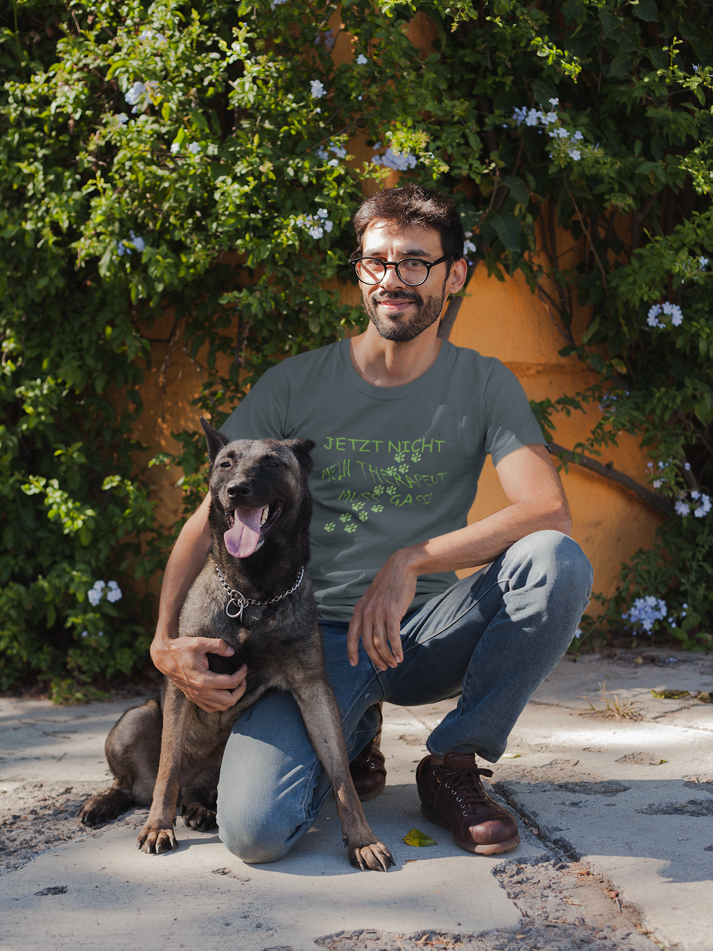 Milkis Way Statement Shirt für Hundefreunde mit grünem Text, getragen von einem Mann mit Hund im Garten